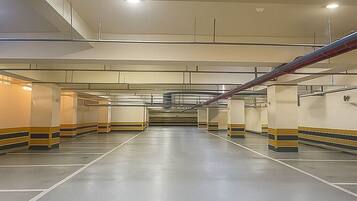 A spacious indoor parking garage with multiple levels and clear signage.