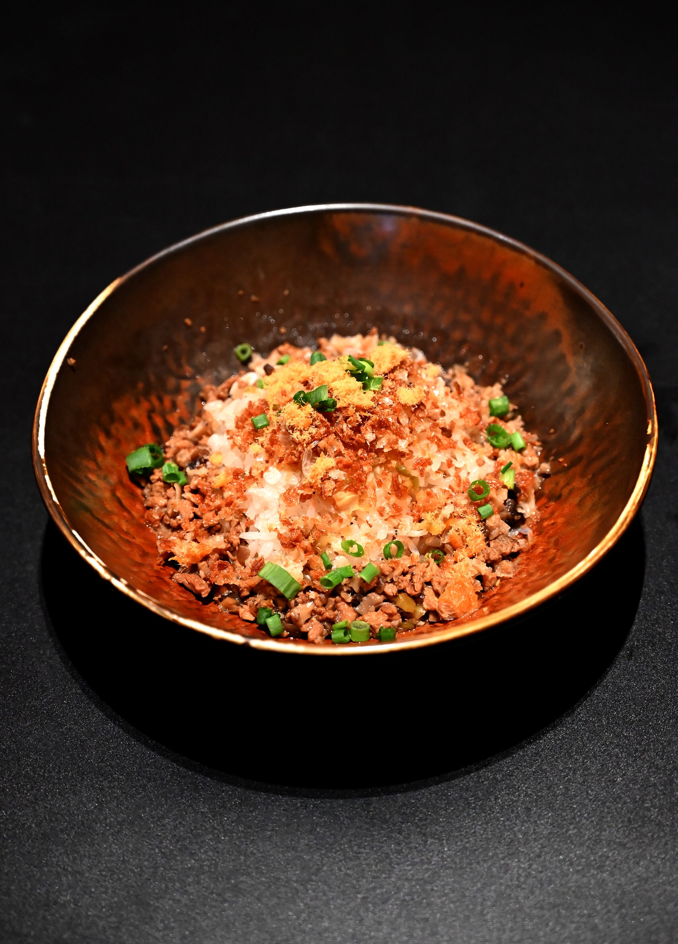 A bowl of food with a dark background.