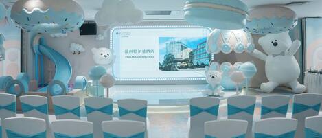 Zona de juegos infantiles con toboganes, una gran estatua de oso y un letrero del hotel Pullman Wenzhou.