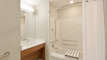 A modern bathroom with a shower, a sink, and a mirror.