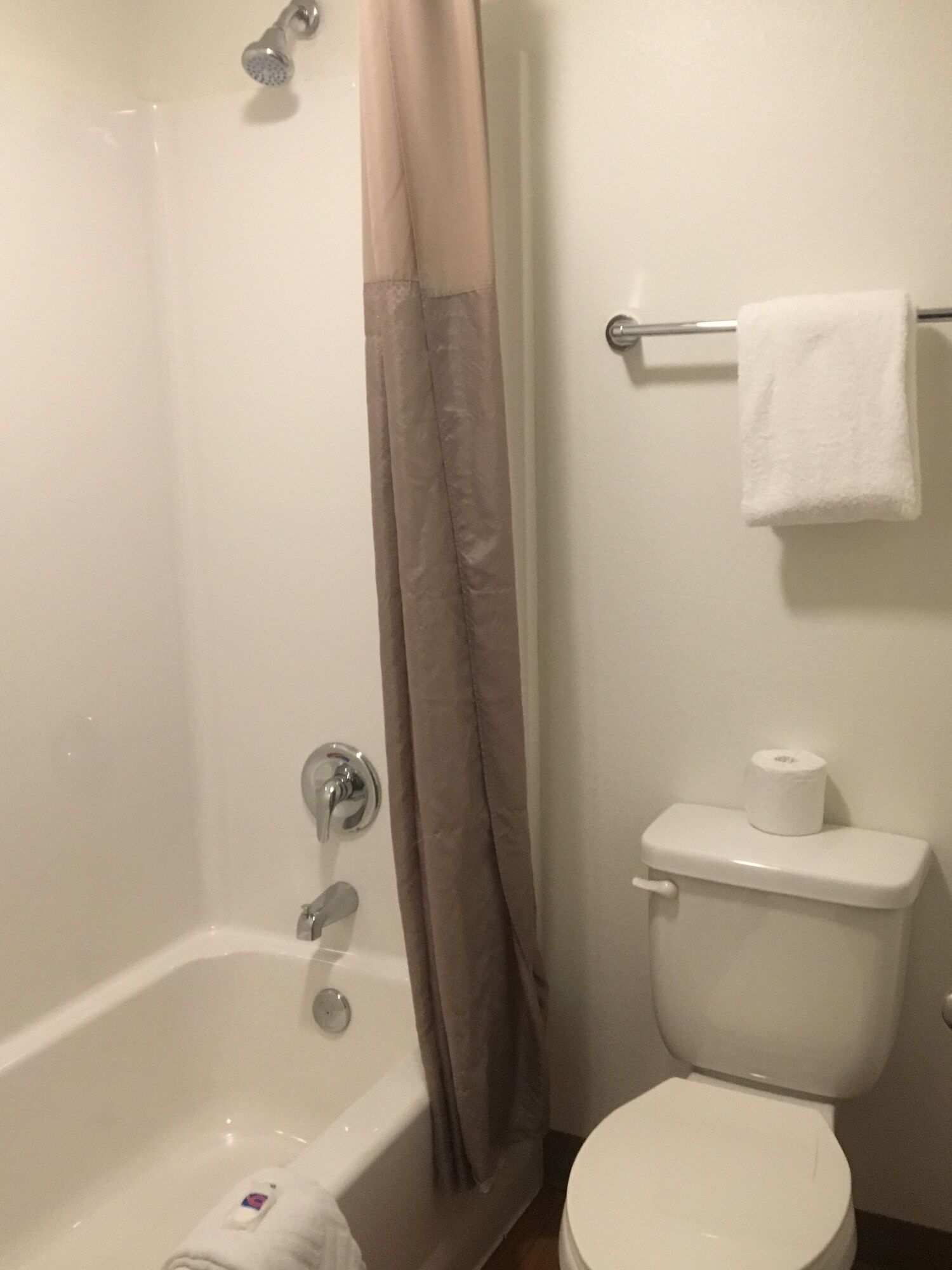 A bathroom with a bathtub, toilet, and shower curtain.