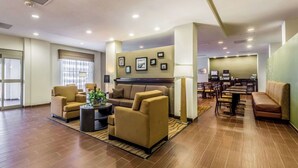 A spacious lobby with a sofa, chairs, a coffee table, and a reception desk.