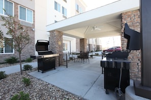 An outdoor patio with a barbecue grill, a dining table, and chairs. - Candlewood Suites Columbia East by IHG (Columbia)