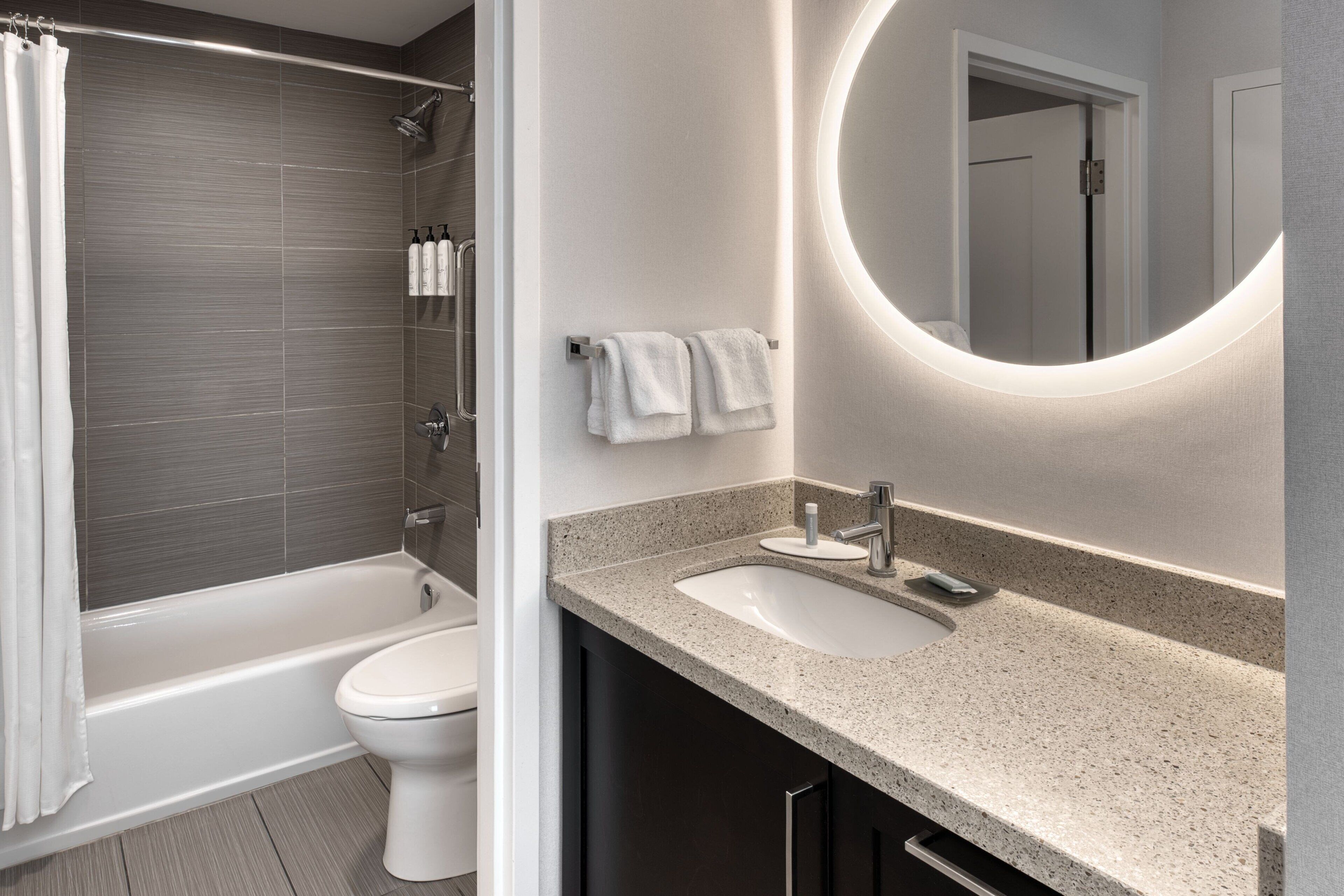 A modern bathroom with a bathtub, toilet, and sink.
