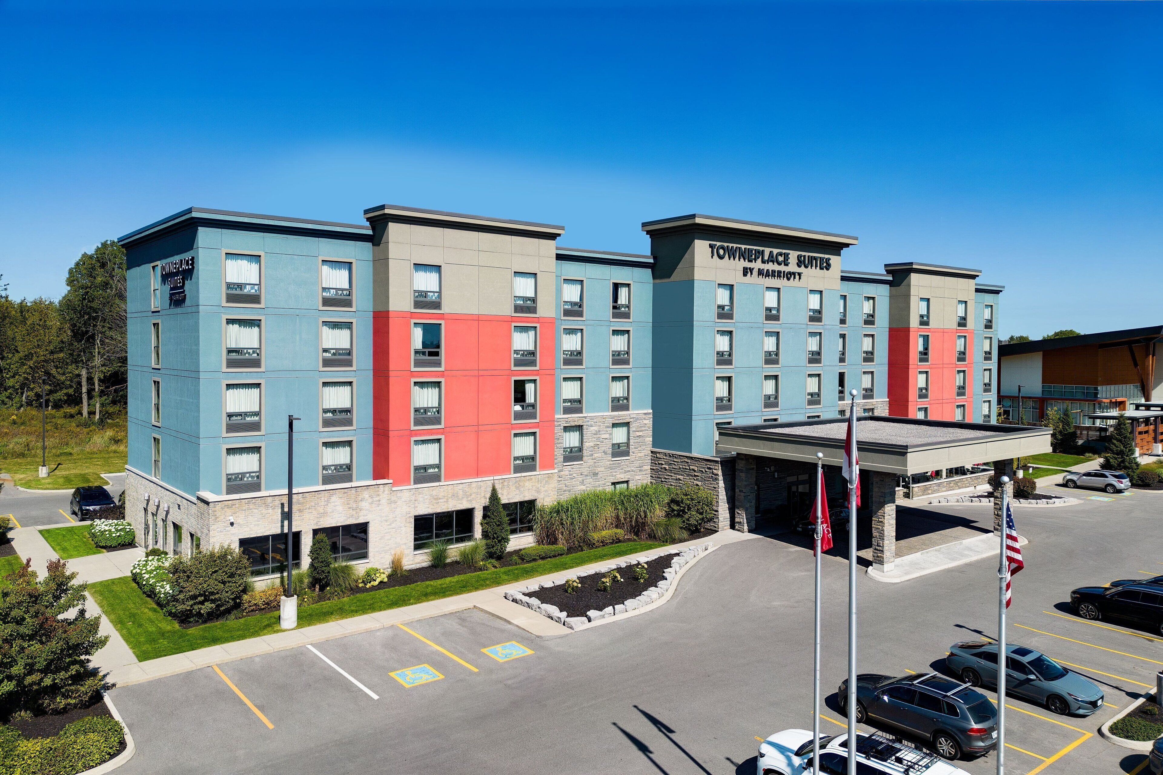 A multi-story hotel with a parking lot in front.