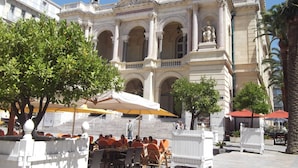 A historic building with classical architecture, including columns and statues.