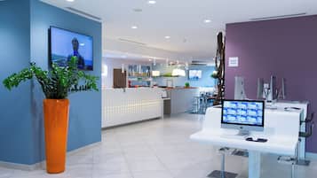 A reception area with a desk, computer, and a plant.