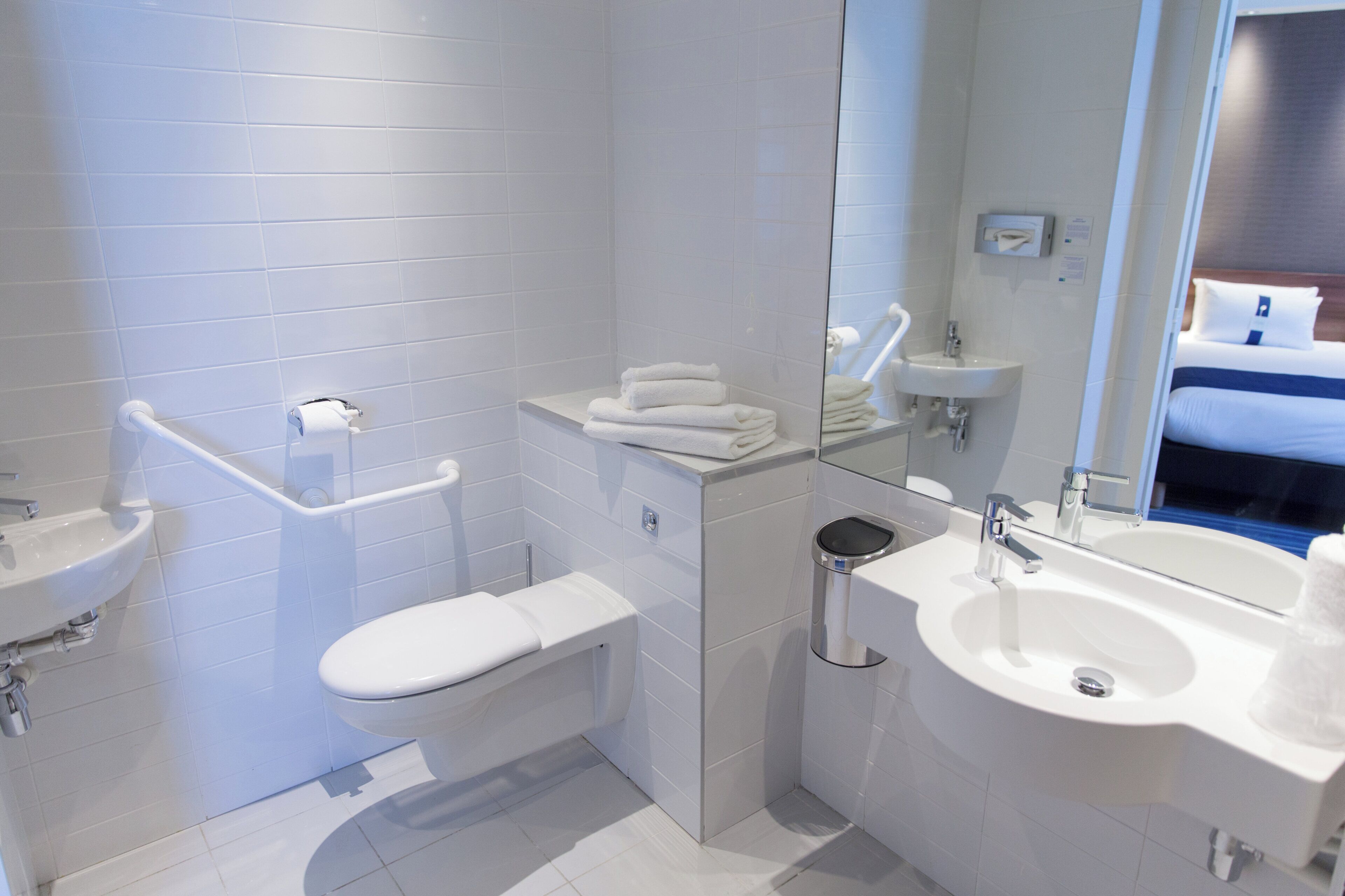 A modern bathroom with a toilet, sink, and mirror.