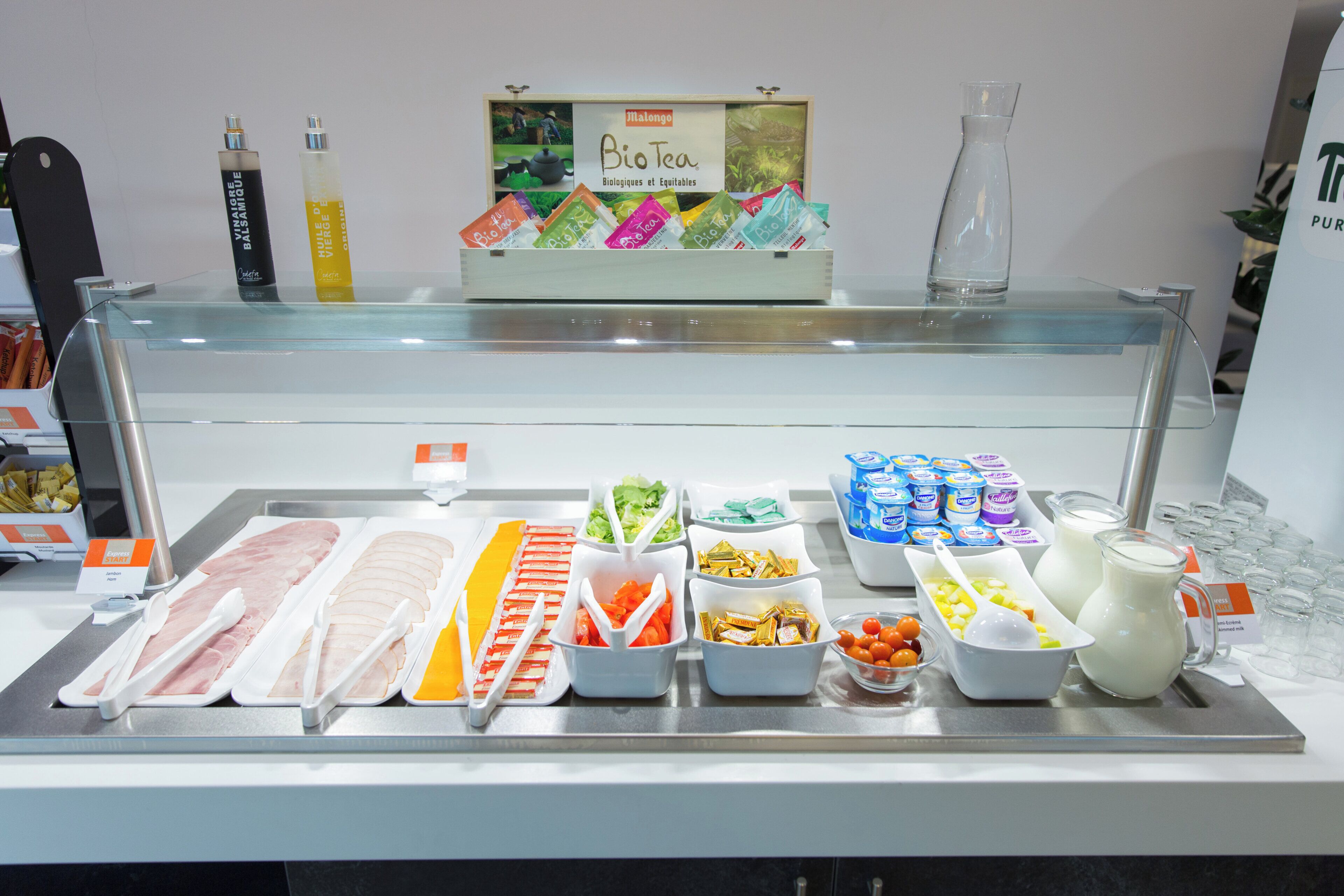 Un espace buffet proposant divers plats et une sélection de thés biologiques.