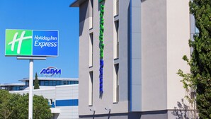 A building with a sign for Holiday Inn Express and a logo for ACGM. - Holiday Inn Express Toulon - Est by IHG (Toulon)