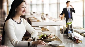 Interior de restaurante con una mesa para dos, preparada con una ensalada y un plato principal.