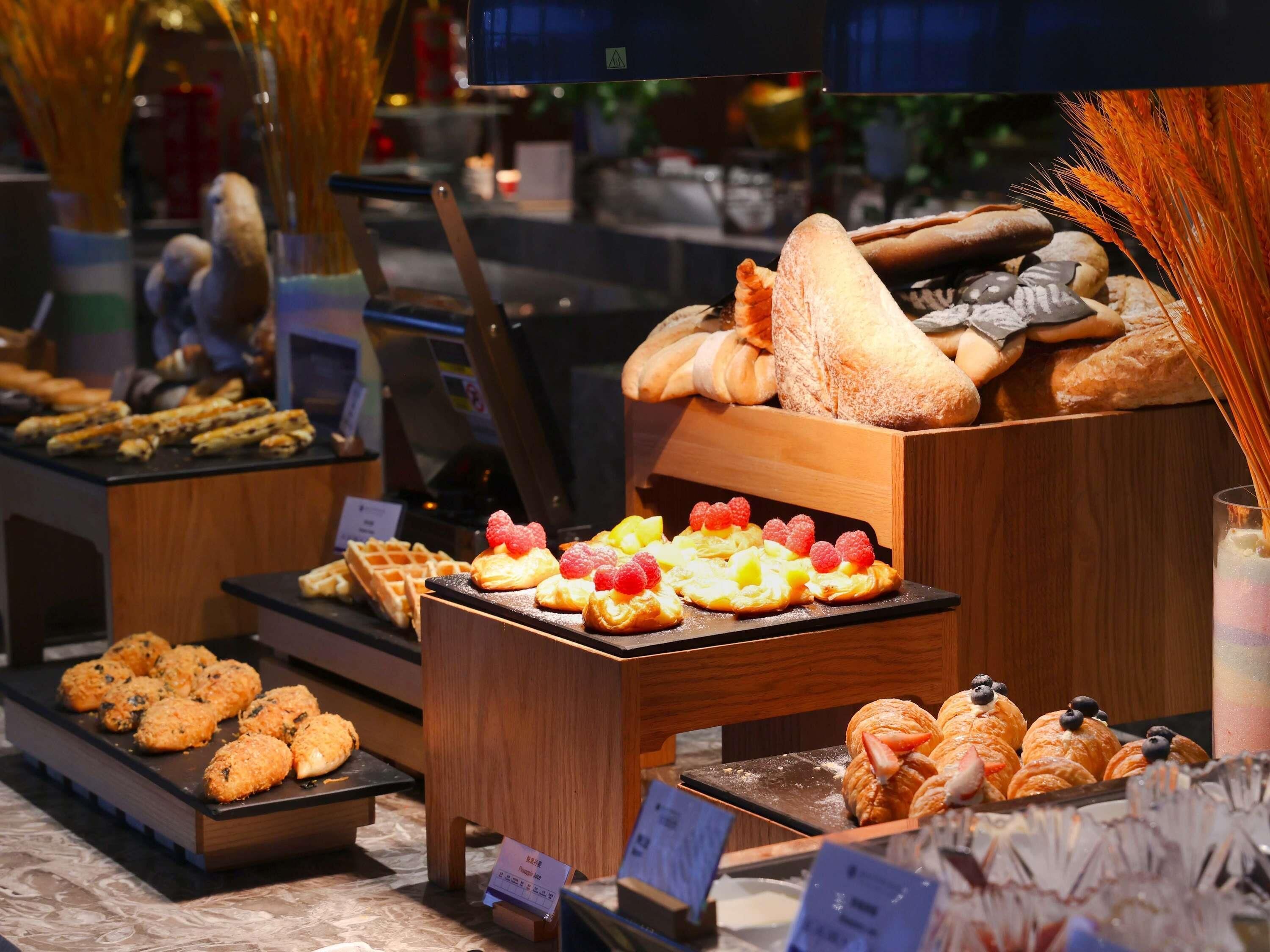 A variety of pastries and baked goods displayed in a bakery section of a hotel.