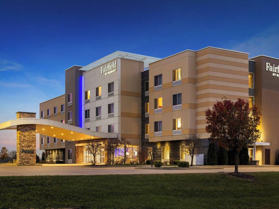 Um hotel Fairfield by Marriott de vários andares com design moderno, apresentando uma entrada notável e um jardim frontal bem cuidado.