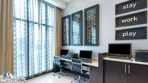 A modern office space with two desks, two chairs, and a cabinet with a printer.