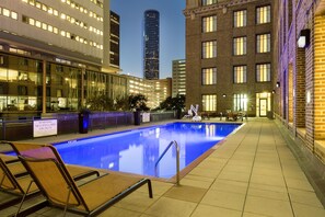 Una piscina al aire libre, tumbonas