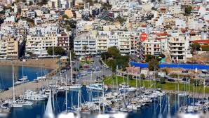 A marina with numerous boats docked, surrounded by densely packed buildings with balconies. - Atlantis Hotel (Agios Nikolaos)