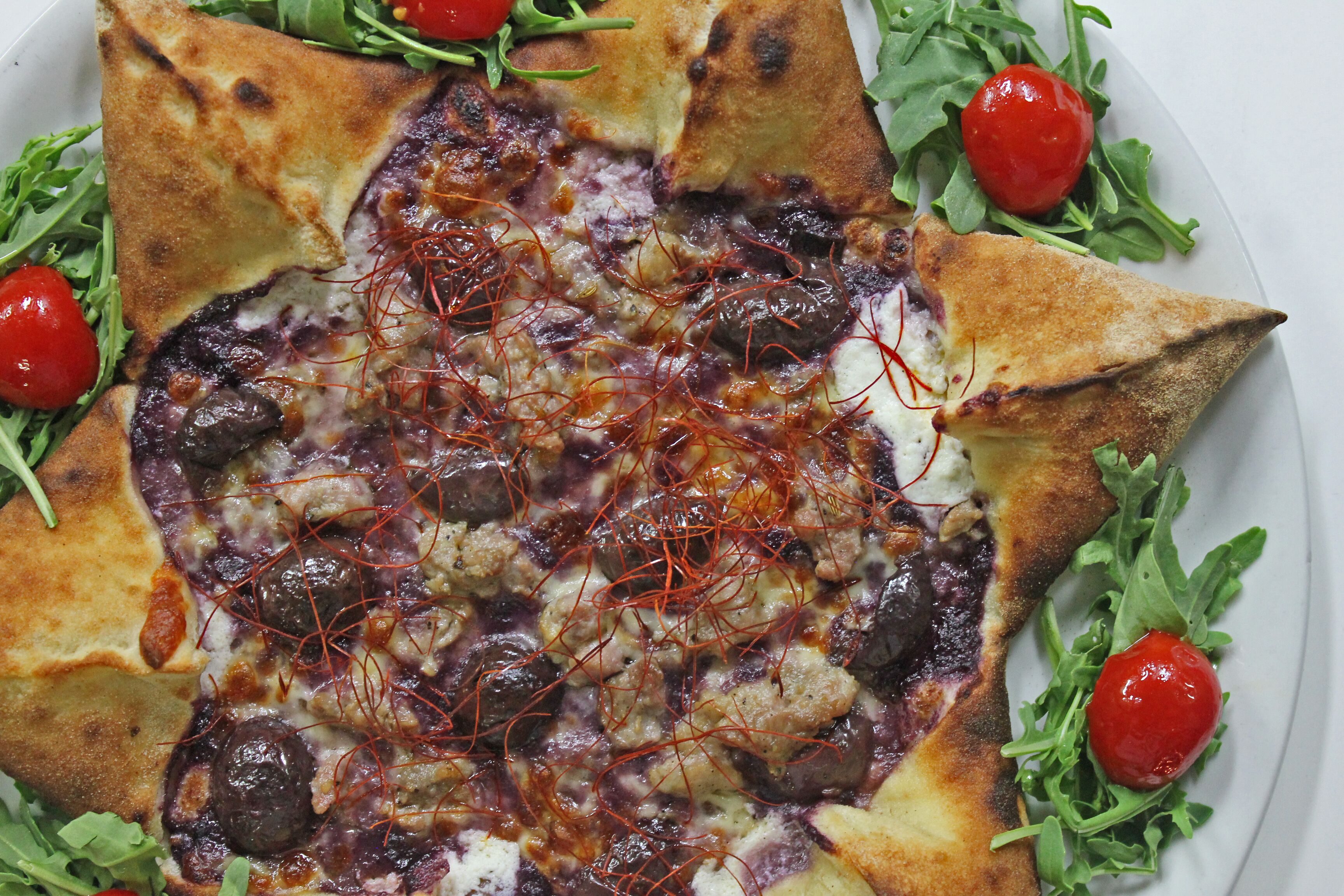 Una pizza con condimenti e guarnizioni su un piatto.