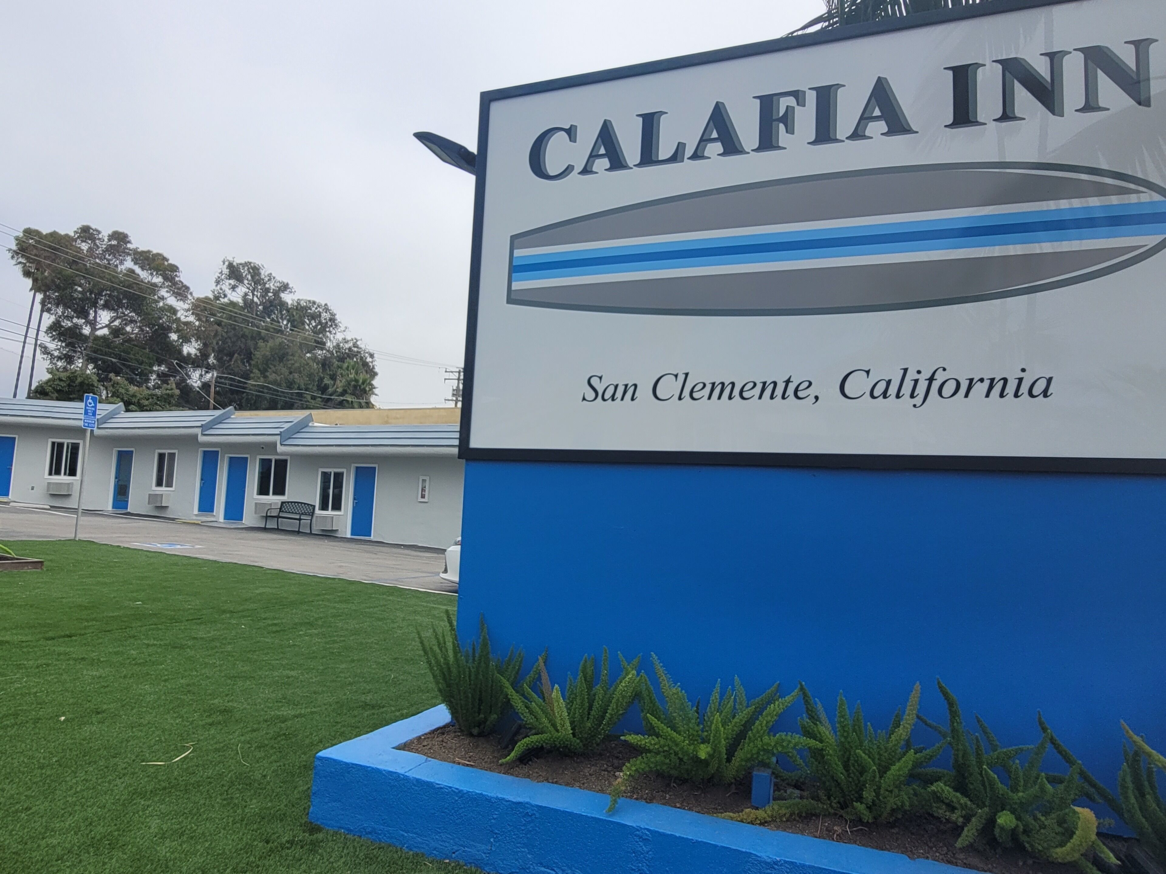 Señal del Calafia Inn en San Clemente, California, que muestra un diseño de edificio sencillo y un área verde delantera.
