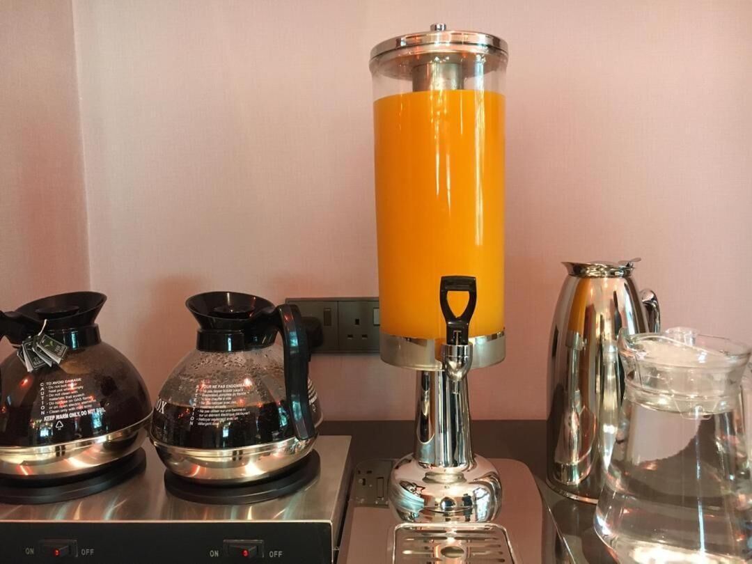 A kitchen with a coffee maker, a kettle, and a water dispenser.