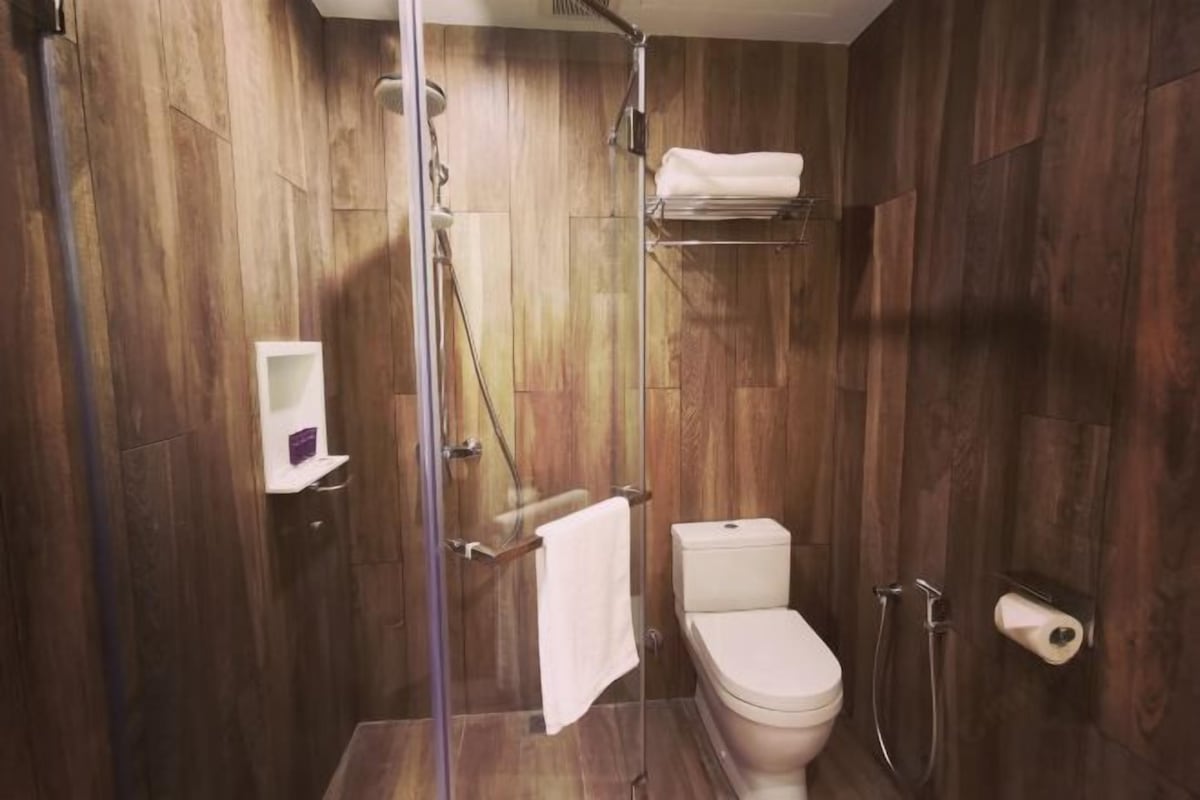 Un baño moderno con ducha, inodoro y toallero.