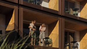 A modern building with a balcony where a family is standing. - Hotel Mari Pop (Ried im Zillertal)