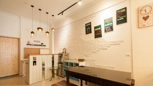 Una cocina moderna con paredes de ladrillo blanco, iluminación colgante y una mesa de comedor de madera.