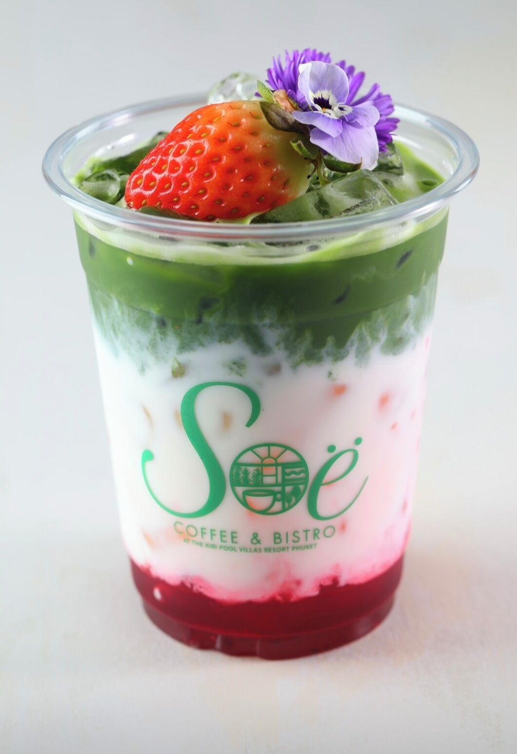 En lagdelt dessert i et glas med logoet "Soé Coffee & Bistro".