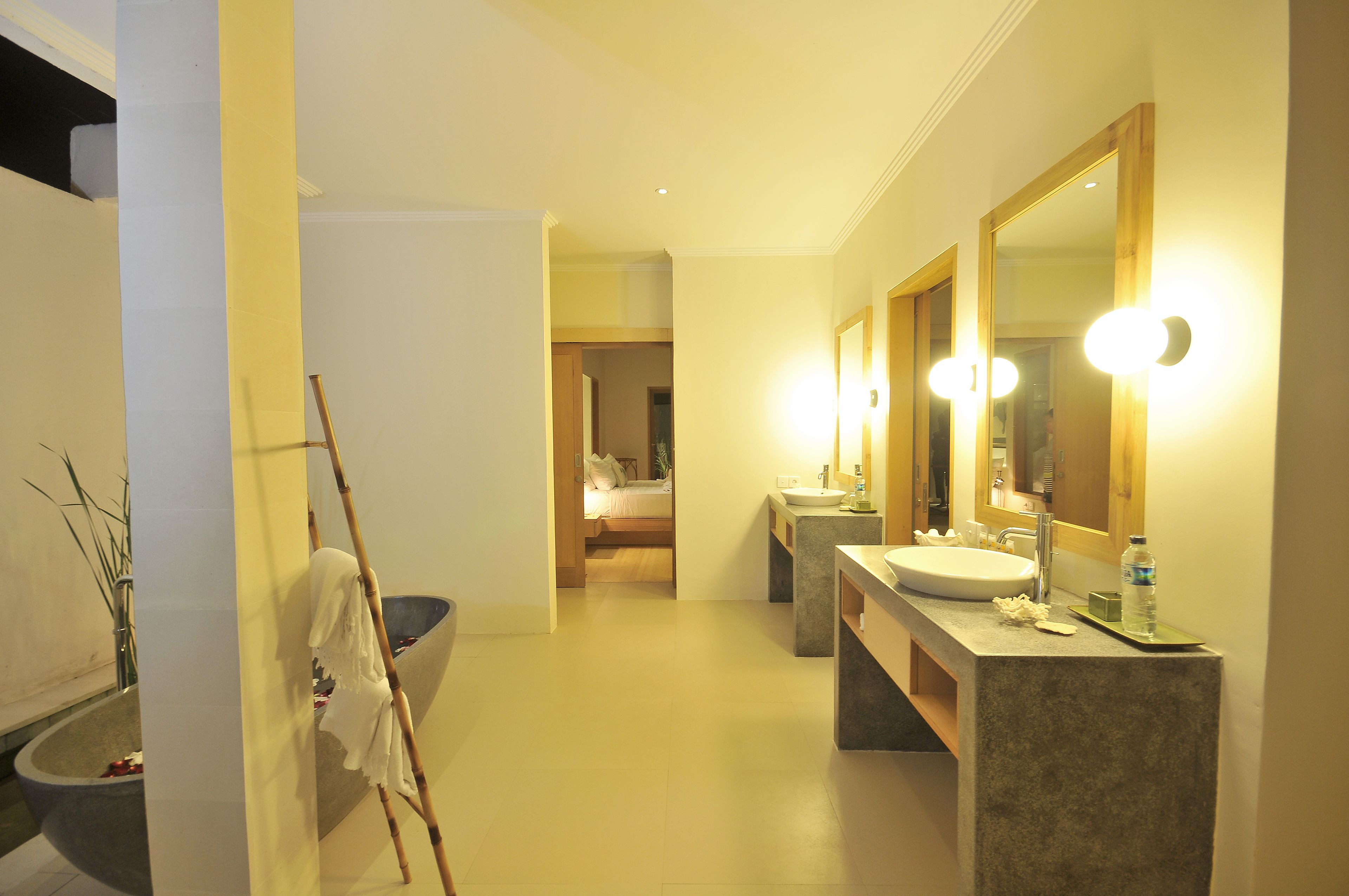 Une salle de bain moderne avec un grand miroir, deux lavabos et une baignoire.