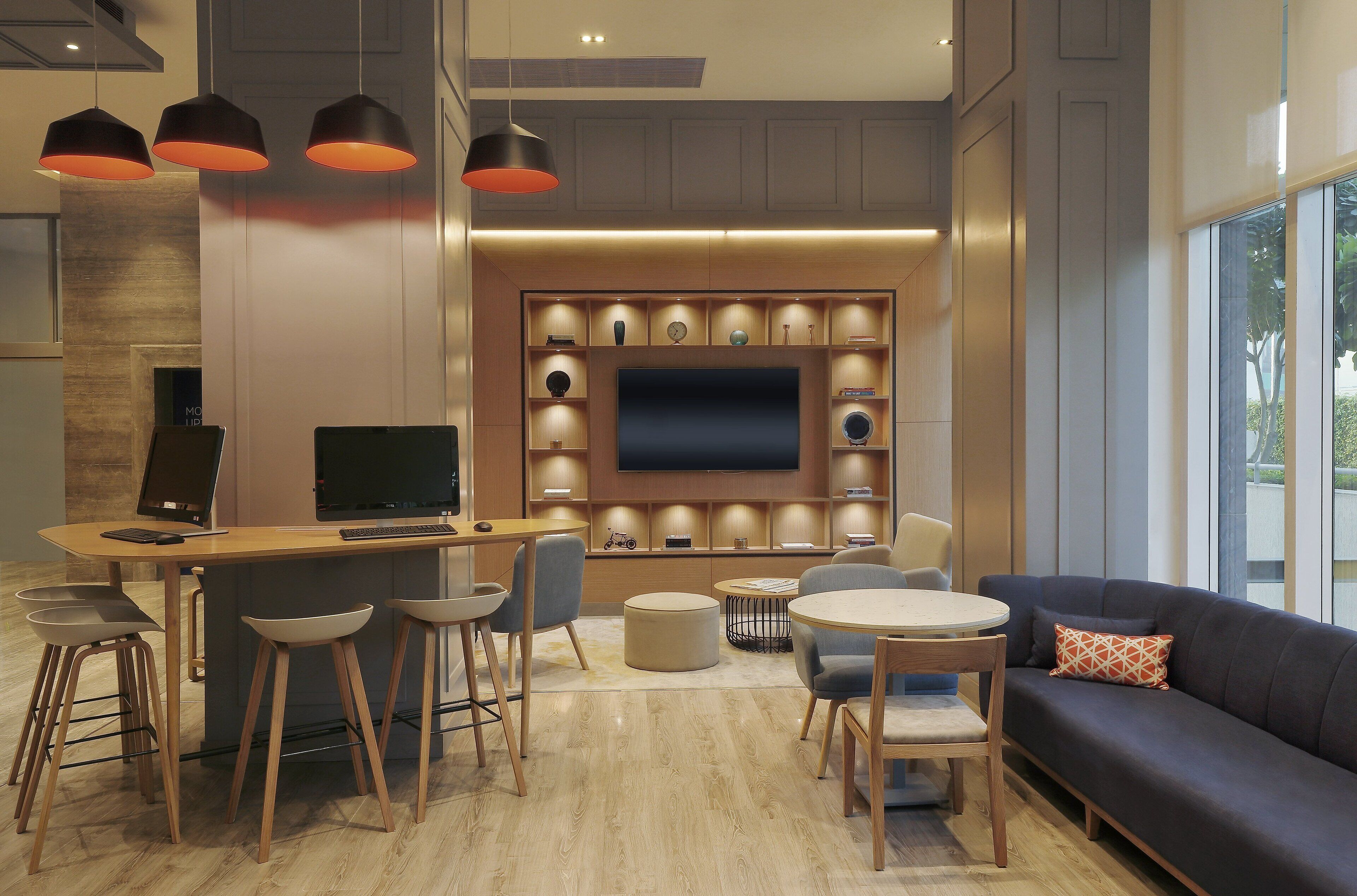 A modern living room with a dining area, a sofa, and a TV wall unit.