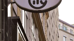 A building with a sign that reads "PENSION" and a symbol of a person with a heart. There are flags hanging from the building. - City Pension Stephansplatz I Self Check In (Vienna)