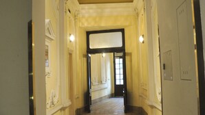 A corridor with a tiled floor, white walls, and a ceiling with a skylight. - City Pension Stephansplatz I Self Check In (Vienna)