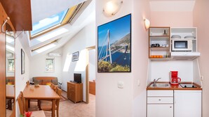 A modern kitchen with a microwave, coffee maker, and sink. There is a dining area with a table and chairs, and a living room with a sofa and a TV. - Apartments Vila Adrijana and Fitness Studio Wolf (Baska Voda)