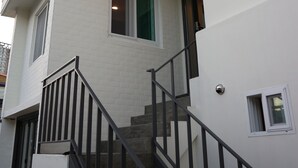 A multi-story building with a staircase and a balcony. - Zzzip Guest House - Hostel (Seoul)
