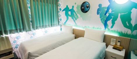 Une chambre d’hôtel avec deux lits, une table de chevet, une lampe et une fresque murale représentant des joueurs de football.