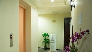 A hotel hallway with a trash bin, a water dispenser, and a potted plant. - Hotel Vistaria (Johor Bahru)