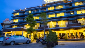 A hotel with multiple floors, a sign reading "TH beach hotel," and several potted plants in the foreground. - TH Beach Hotel (Hua Hin)