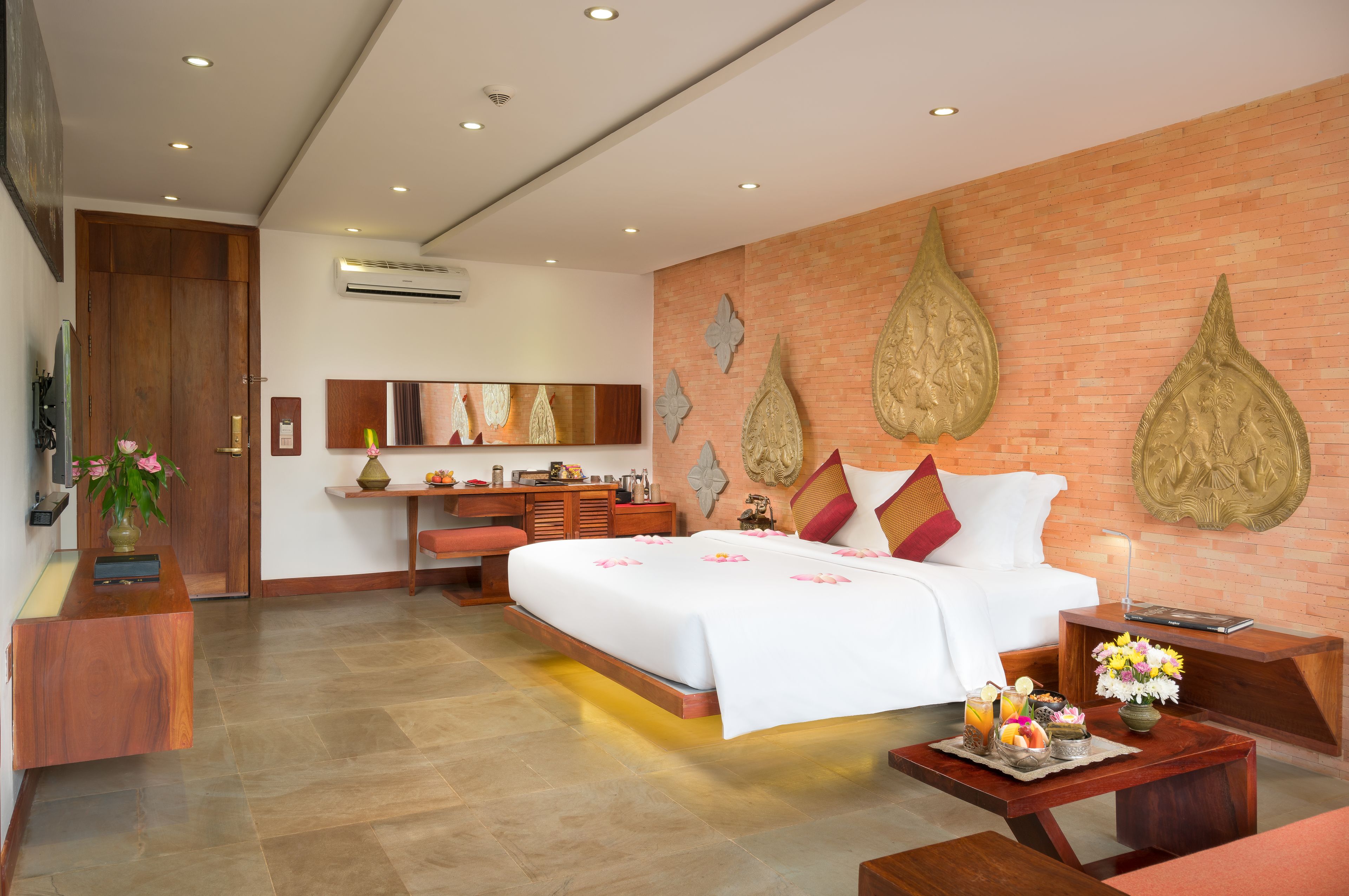 Una habitación de hotel moderna con una cama grande, un escritorio, una tocador y una zona de estar.