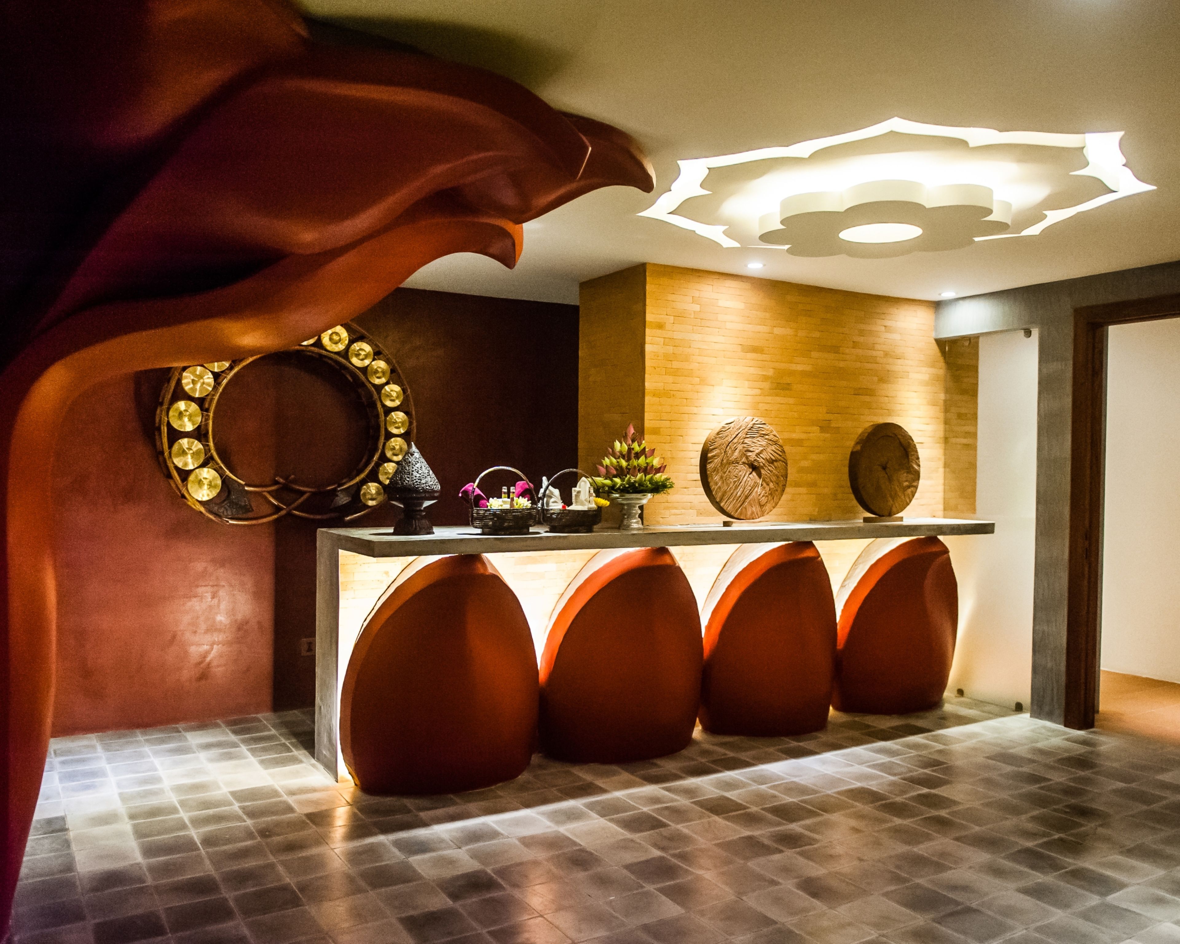 A modern reception area with a unique ceiling design, a wooden wall, and a tiled floor.