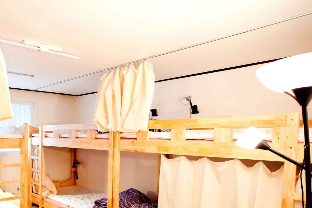 A room with bunk beds, a desk, and a lamp.