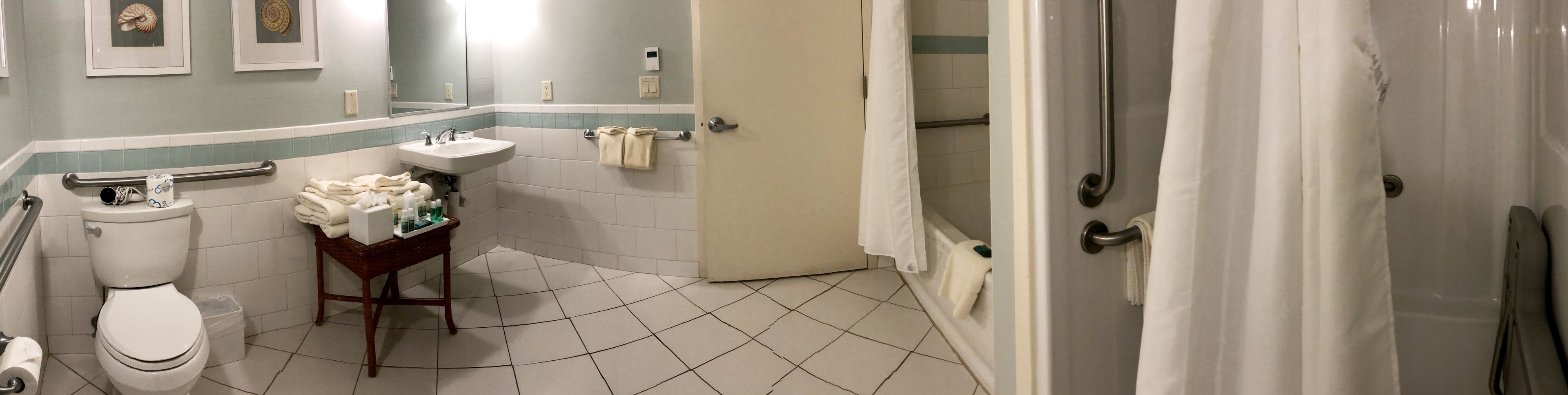 A bathroom with a toilet, sink, and shower area.