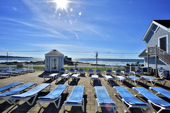 A beachside lounge area with sun loungers and a gazebo overlooking the ocean.