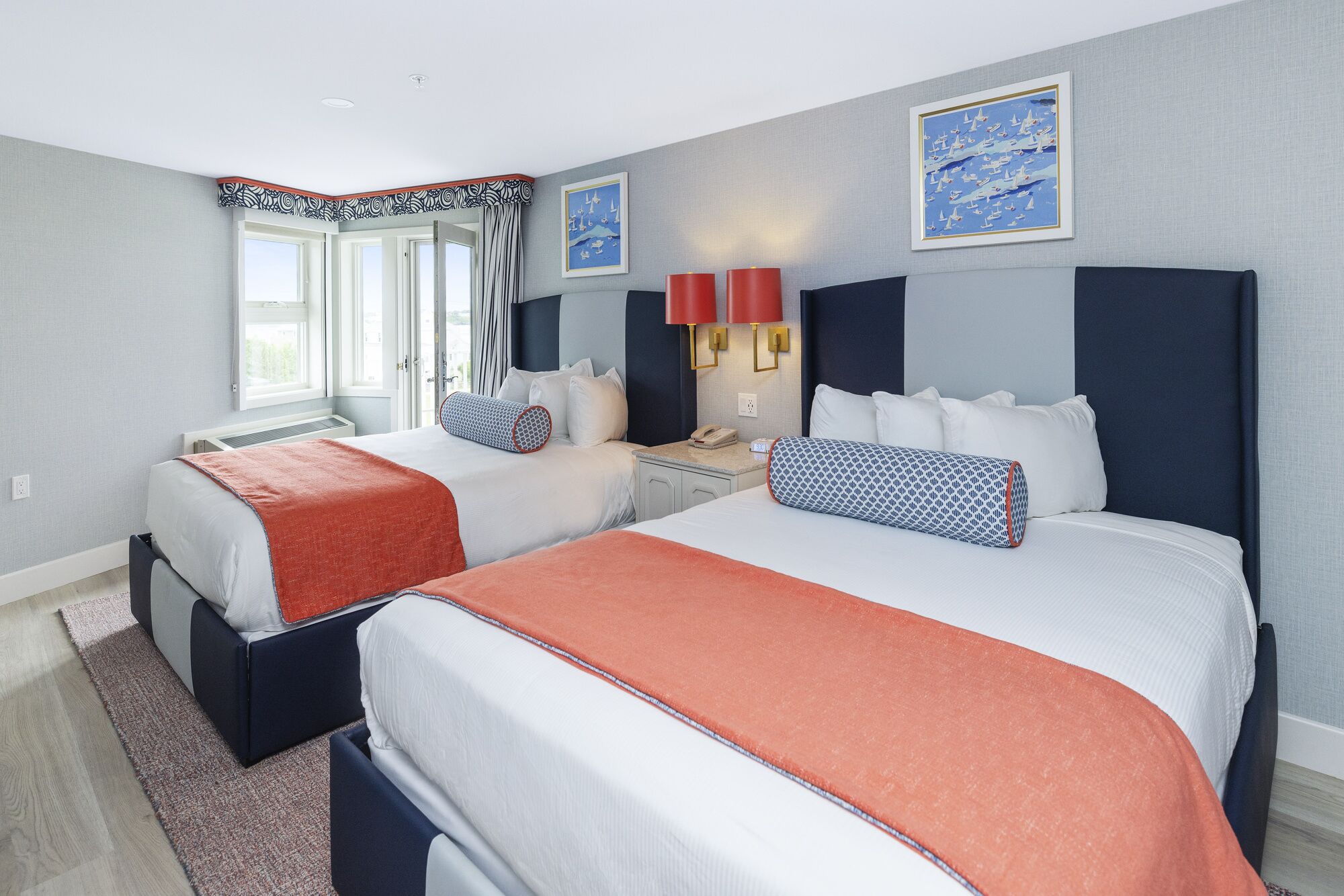 Habitación de hotel con dos camas, una mesita de noche y una ventana con cortinas.