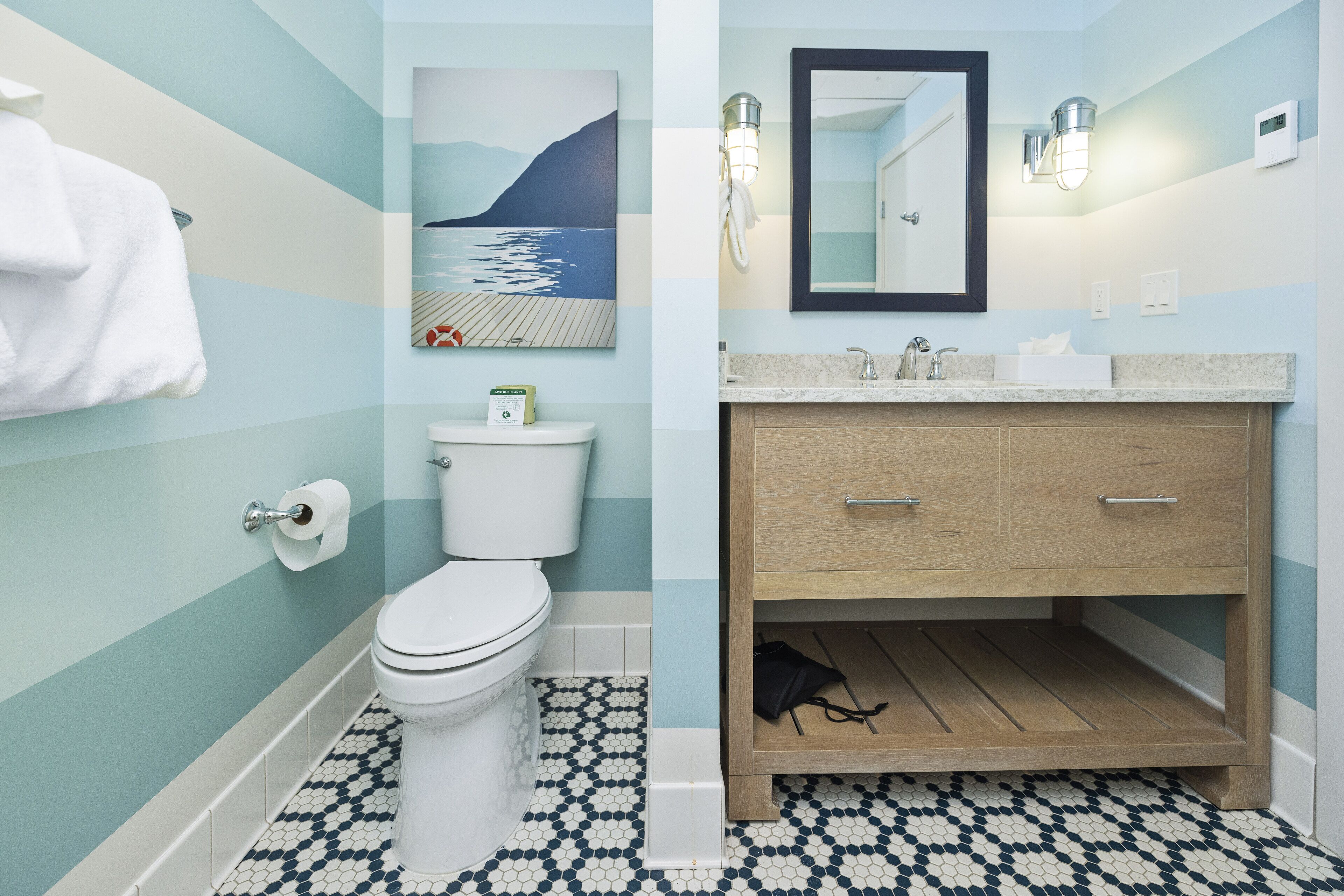 Une salle de bain équipée de toilettes, d’un lavabo et d’un meuble en bois.