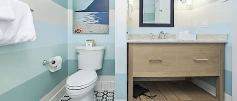 A bathroom with a toilet, sink, and wooden cabinet.
