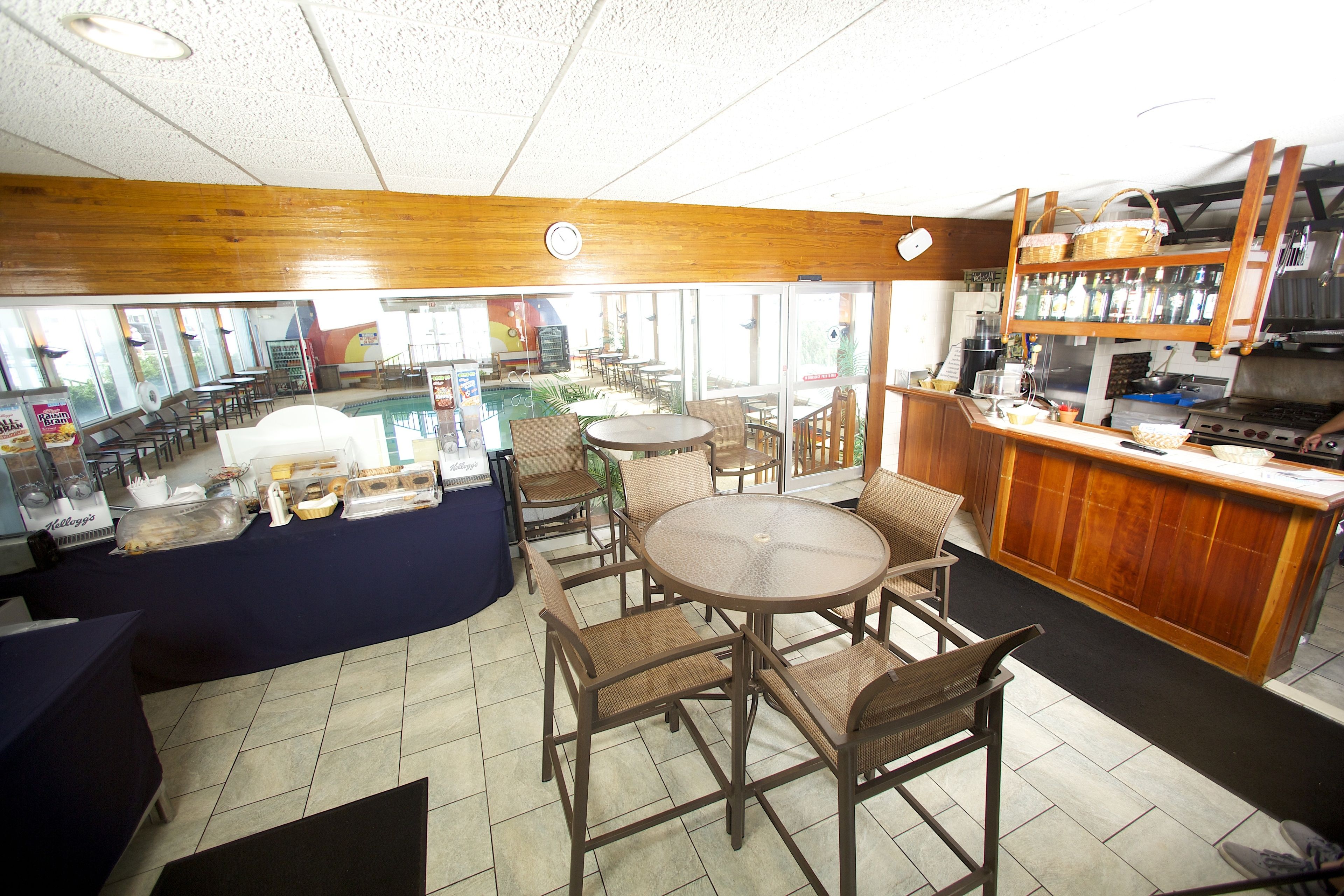 Un ristorante con zona bar, arredi in legno e pavimento piastrellato.