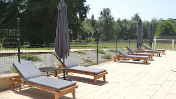 Una piscina al aire libre de temporada, sombrillas