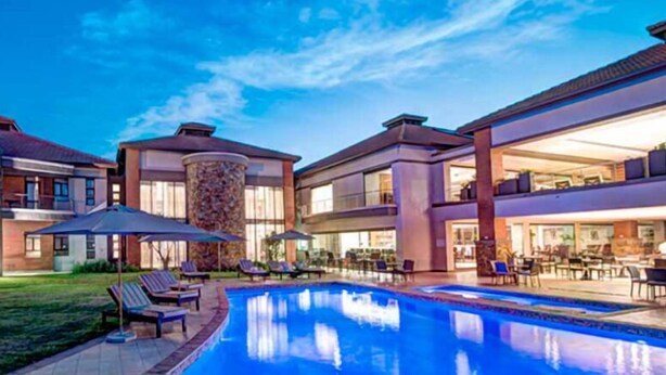 Un hotel moderno con piscina, zona de estar al aire libre y un patio bien iluminado.