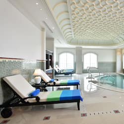 Una piscina al aire libre, sombrillas, sillones reclinables de piscina