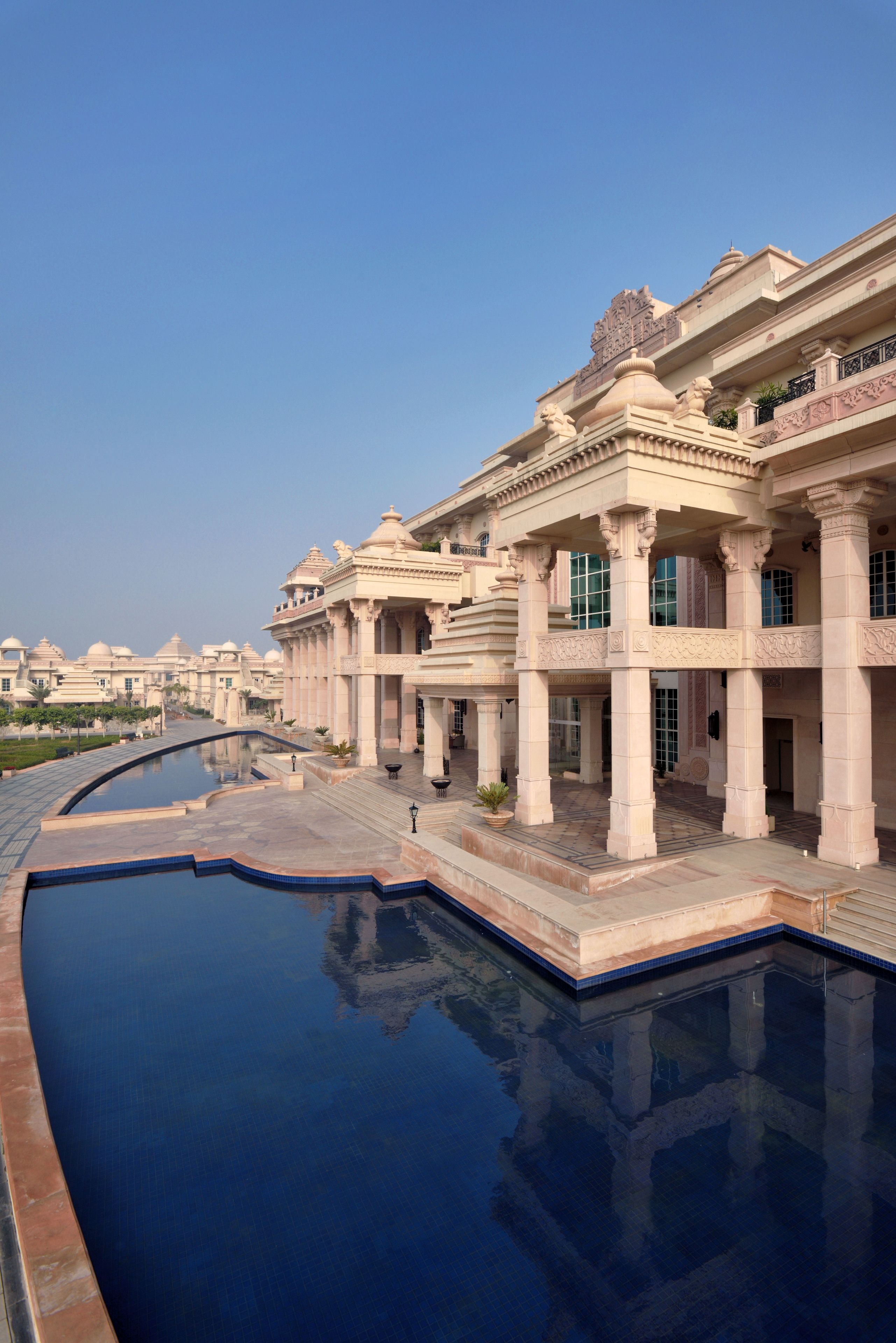 A large, ornate building with multiple columns and a reflecting pool.