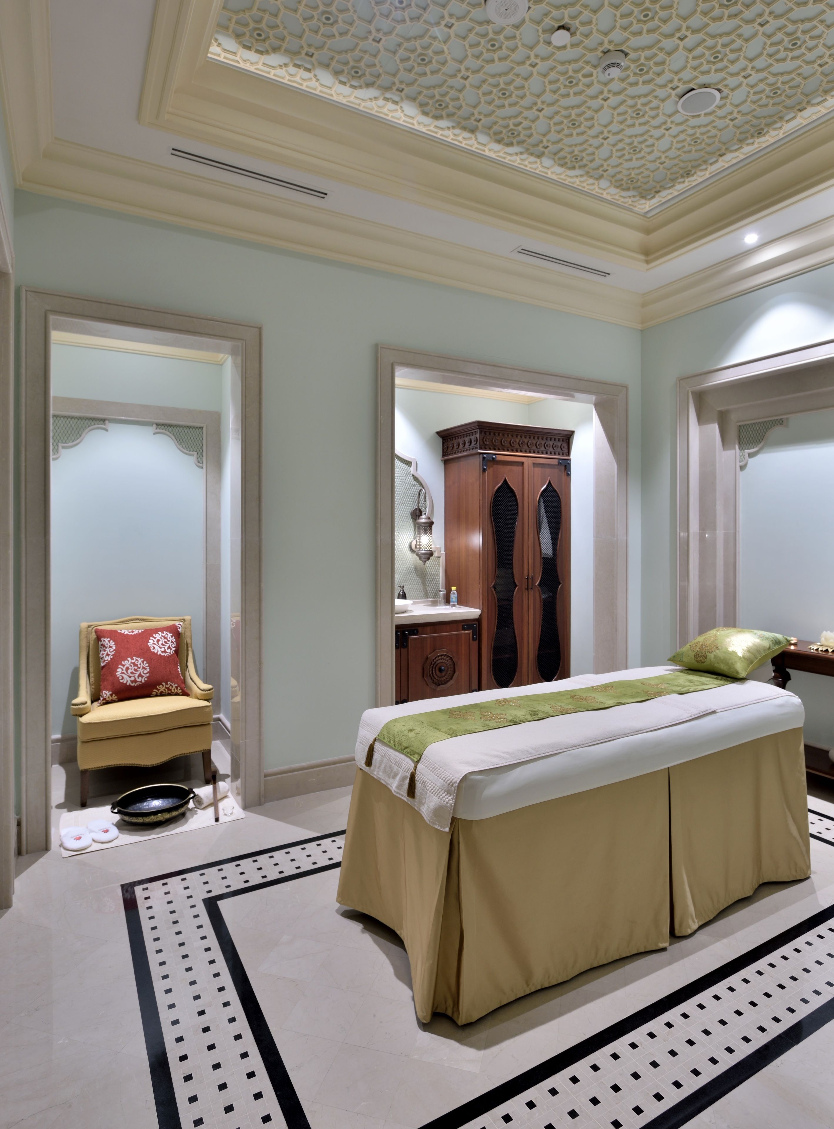 Un dormitorio amplio con una cama grande, una zona de estar con una silla y un tocador con espejo.